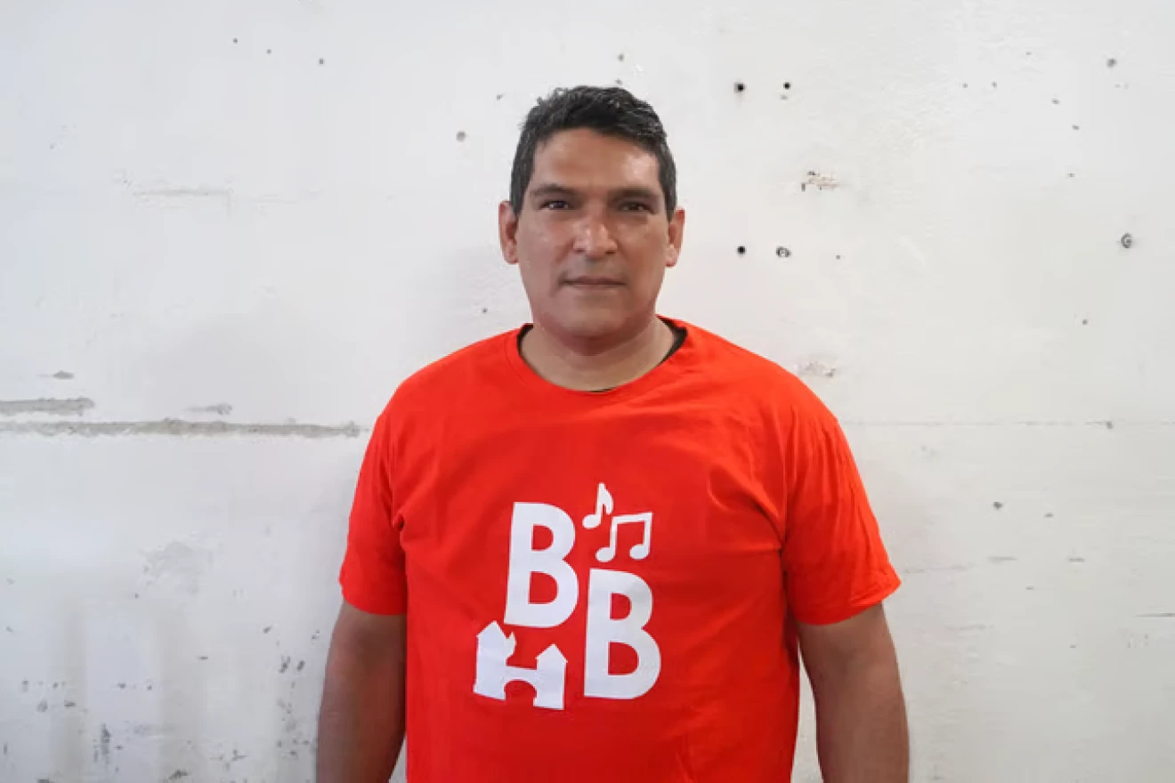 Portraitfoto von Mervin aus Venezuela, er trägt ein rotes T-Shirt von BrugglynBeats.