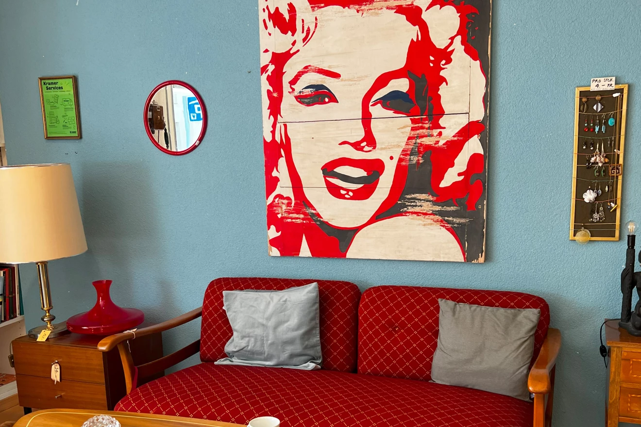 Zu sehen ist der Café-Bereich eines Brockenhauses mit einem gemütlichen Sofa im Zentrum.