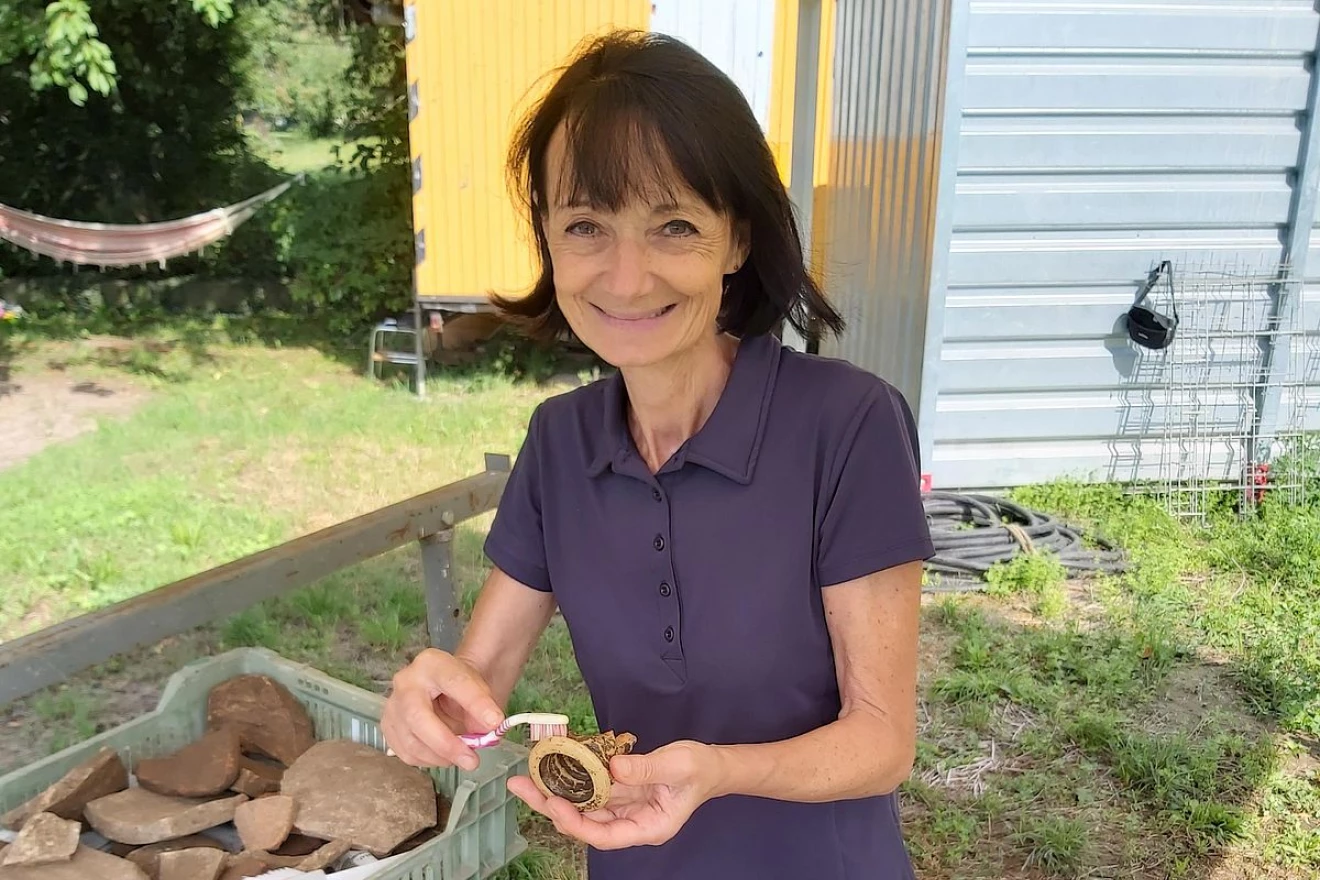 Zu sehen ist eine Freiwillige bei der Reinigung von archäologischen Fundgegenständen.