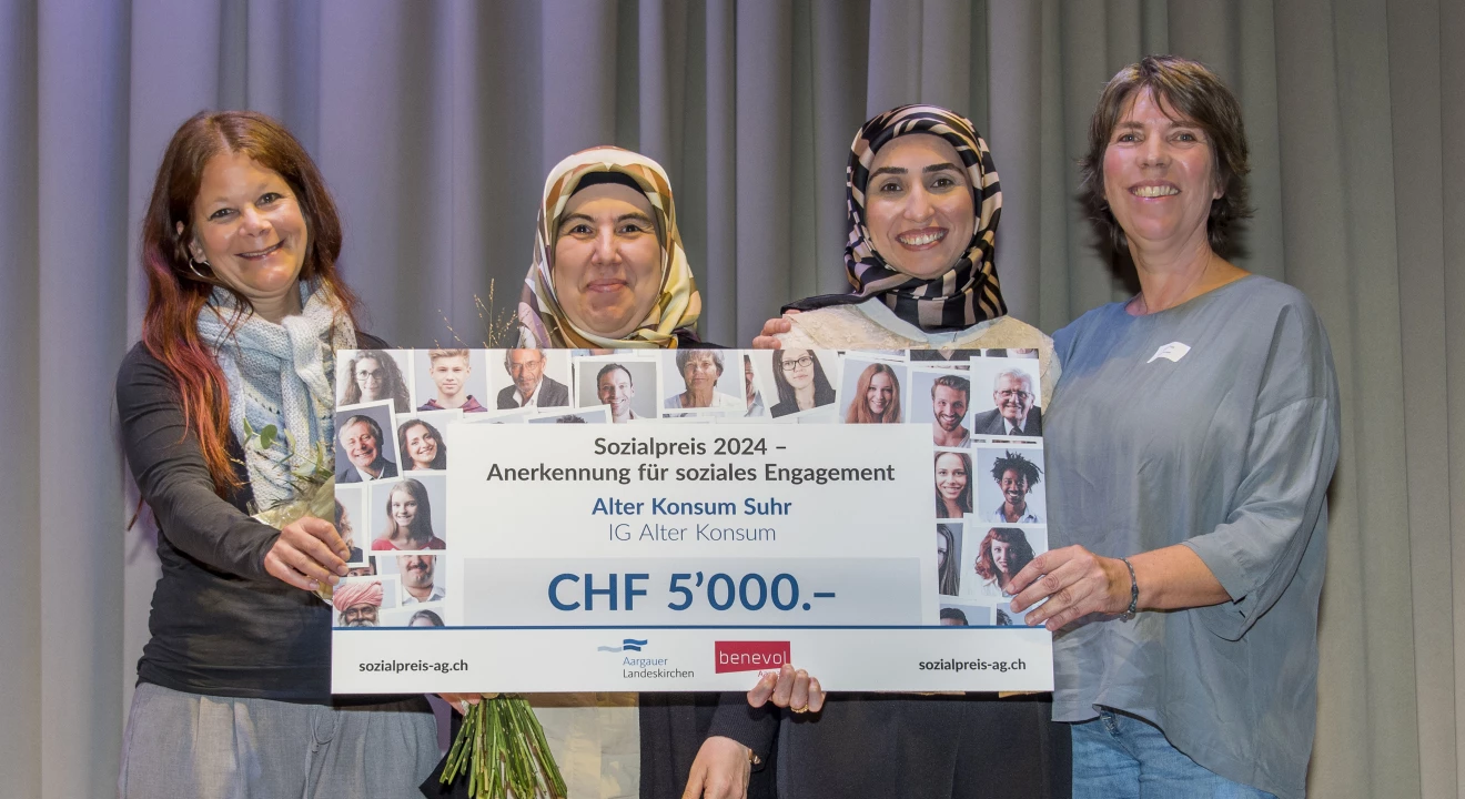 Vier strahlende Frauen halten gemeinsam und stellvertretend für den Alten Konsum einen übergrossen Check, der den Betrag von 5000 Franken zeigt. Der Check symbolisiert ihren Sieg beim Sozialpreis 2024.