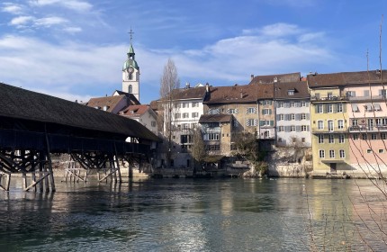 Zu sehen ist eine Holzbrücke, welche über die Aare zu einem Altstadtteil der Stadt Olten führt.